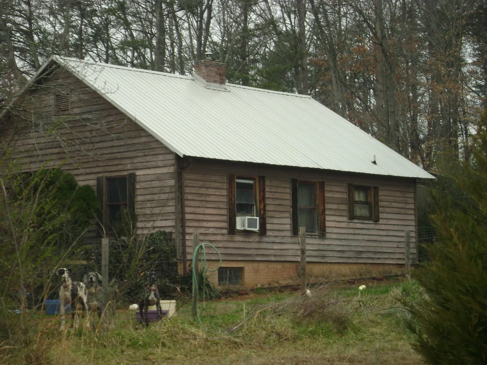 White metal roof on an old wood sided farmhouse, from a Metal Roof Installation job in Artesia